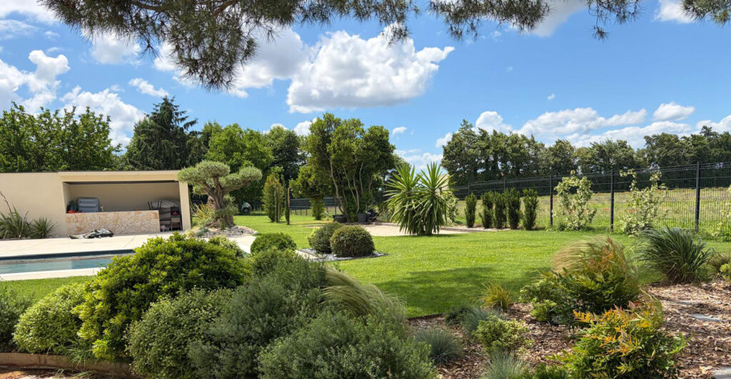 Massifs arrondis et pergola en fond de jardin