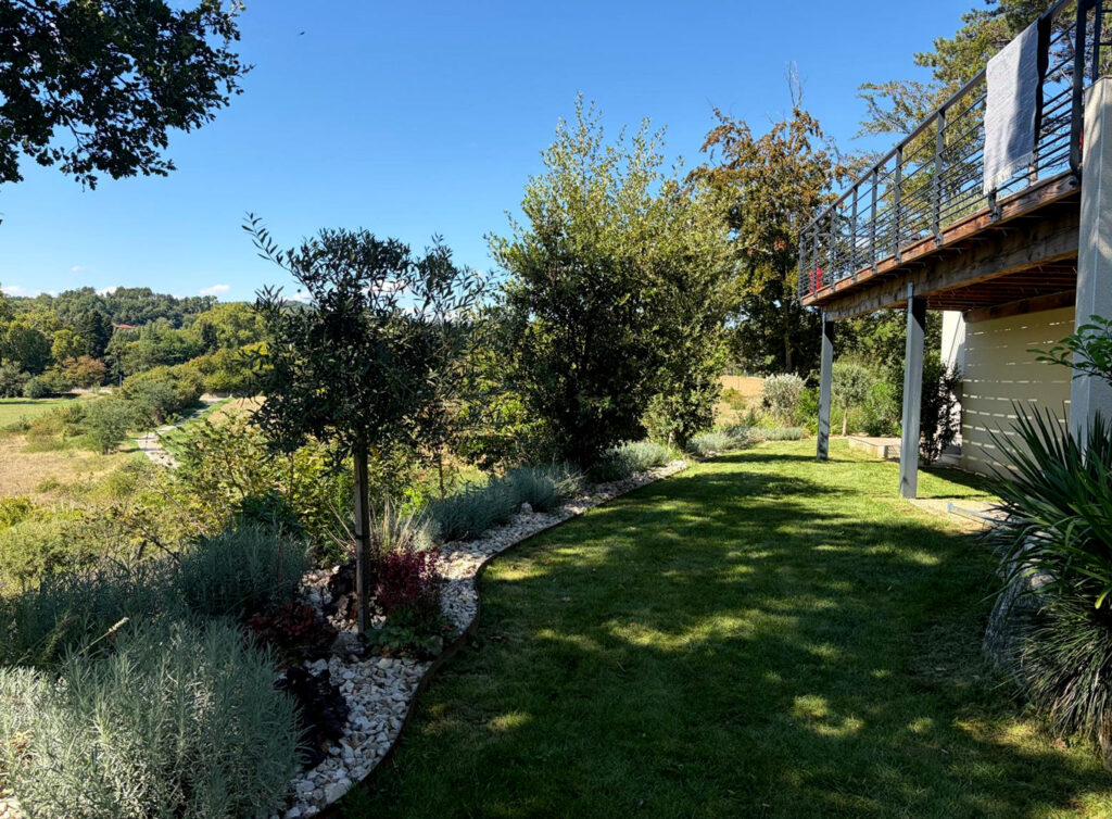 Massifs aux courbes douces au pied de la terrasse, face à la campagne
